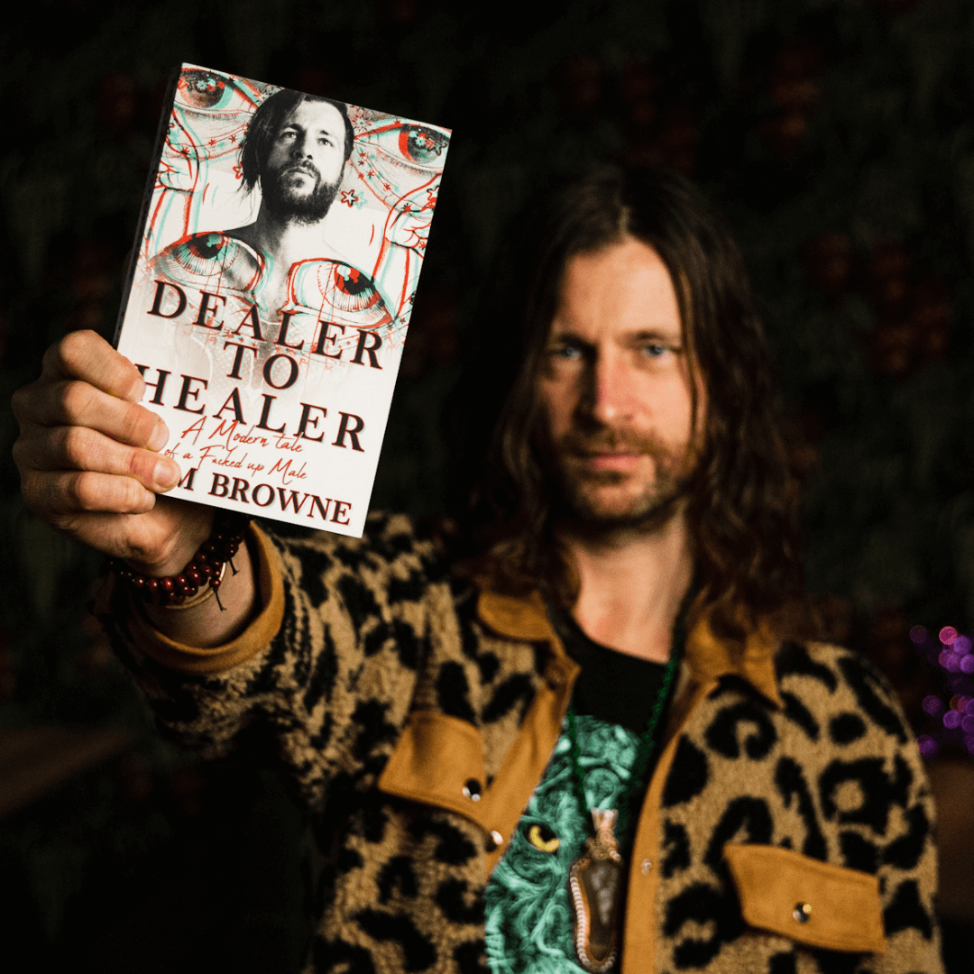 A photo of Liam Browne holding his book Dealer to Healer 